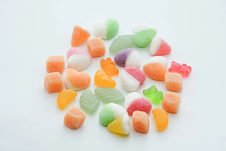 Fruit gummy supplements on white background